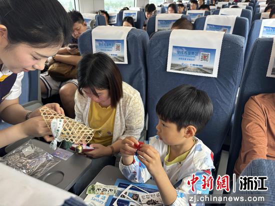 图为：乘务员和旅客进行手工制作。中新社发 高艳 摄