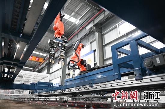 图为：自动化机械臂生产高铁轨道板。中新社记者 王刚 摄
