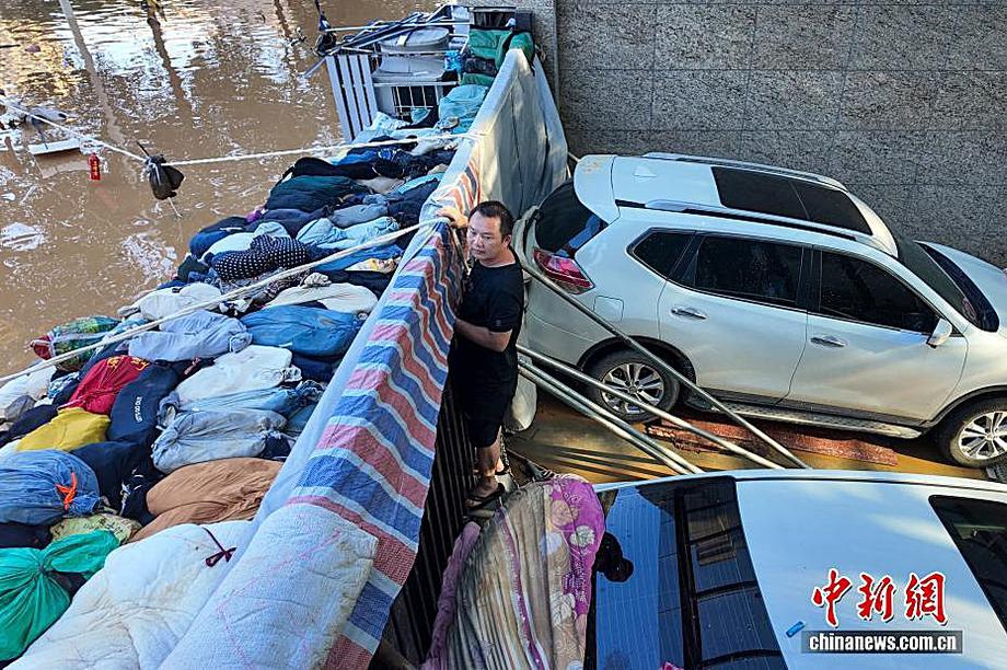 广西贵港：小区业主自制“防水墙” 暴雨中守护上千台汽车