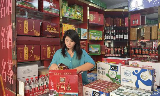 图为吴霞丽正在打包罗城特产。覃春娥 摄