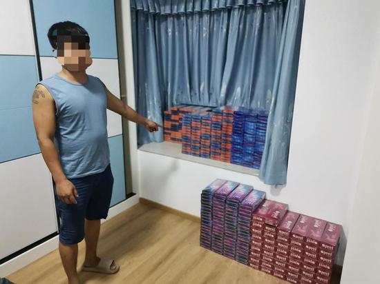 图为涉案人员指认涉案卷烟。黄碧 摄