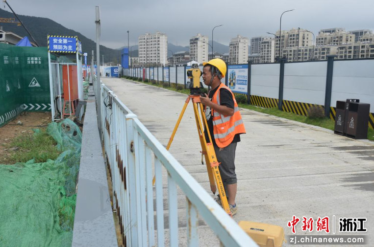 图为：工人正在测量放线。中新社发 卢勇龙 摄