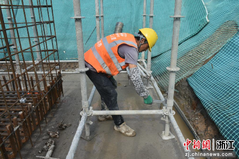 图为：项目工人在紧固脚手架插销。中新社发 梅浩 摄