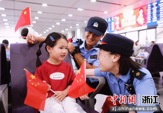 　　
图为：嘉兴站派出所民警与手持小国旗的小朋友亲切交流，在浓浓的国庆氛围中做好便民服务。中新社发 贺瑞明 摄