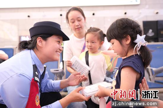 图为：德清站派出所民警向小旅客发放安全宣传小礼品，开展出行安全科普，温情守护出行孩童。中新社发 贺瑞明 摄